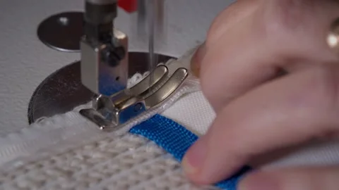 The close-up of the sewing machine needle in slow motion. The seamstress sews Video stock 221179554