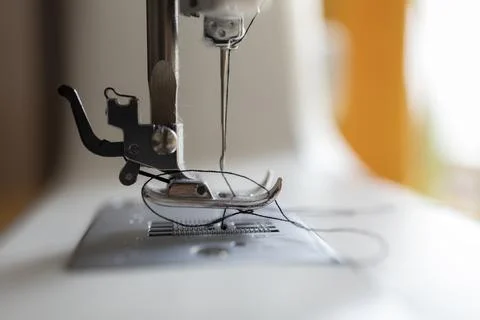 Close-up of sewing machine needle with threaded fabric. Stock Photos