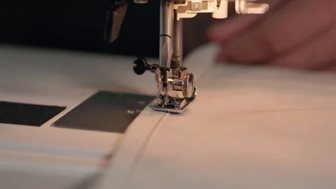 Close up of sewing machine presser foot stitching linen fabric at home Stock Footage 345456559