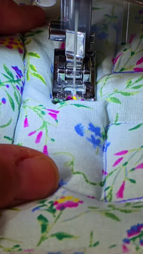 Close-Up of Sewing Machine Stitching Floral Fabric Stock Footage 314772914