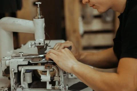 Close up of sewing machine working part with leather. The master's hands sews a Stockfoto's
