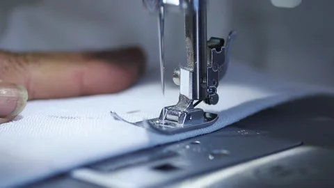 Close-up of sewing machine working with a white fabric. Видео 225584145
