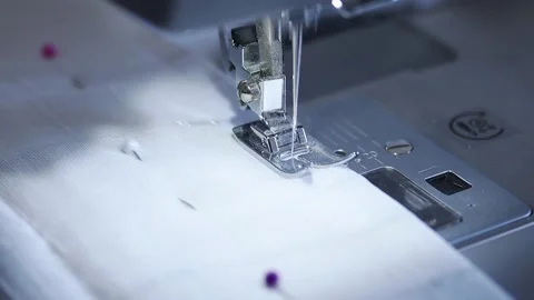 Close-up of sewing machine working with a white fabric. Stock Footage 225584246