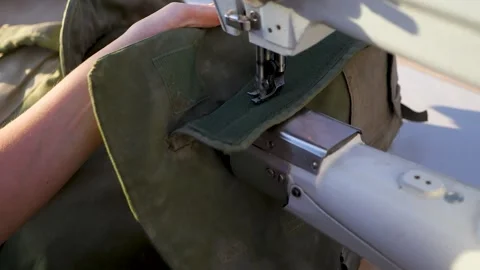 Close up sewing torn Israeli IDF soldier's clothes Stock Footage 296399382