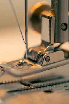 Close-up in a sewing workshop thread is inserted into a needle on a machine Stock Photos