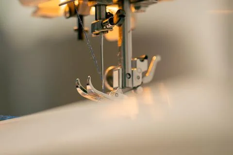 Close-up in a sewing workshop thread is inserted into a needle on a machine Stock Photos