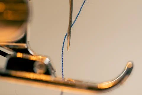 Close-up in a sewing workshop thread is inserted into a needle on a machine Foto stock