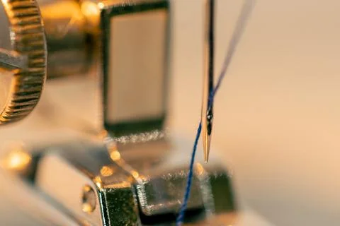 Close-up in a sewing workshop thread is inserted into a needle on a machine Stock Photos