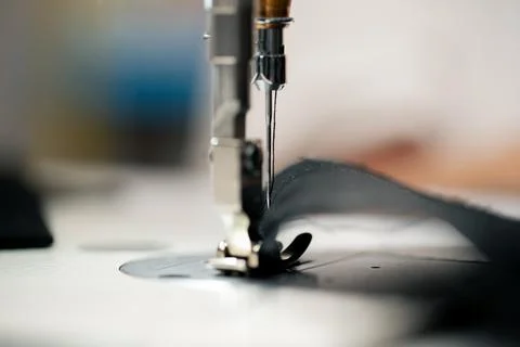 Close-up in a sewing workshop thread is inserted into a needle on a machine Foto stock