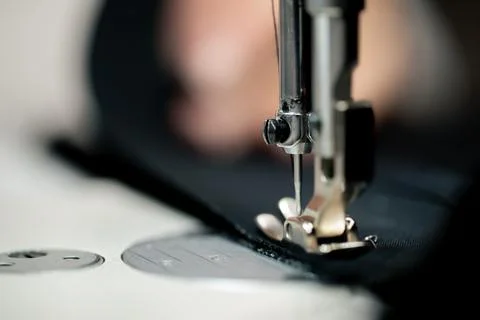 Close-up in a sewing workshop thread is inserted into a needle on a machine Foto stock