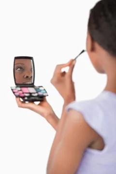 Close up of shadowing woman while applying make-up against a white background Stock Photos
