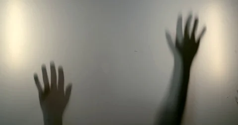 Close-up shadows of a woman's hands and silhouette reflected behind the glass. Stock Footage 118825910