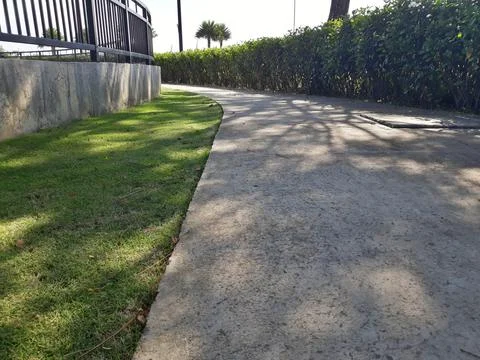 Close up of shady path with green grass on the side Stock Photos