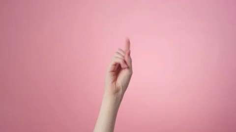 Close-up of a shaking finger on a pink background Stock Footage 171538928