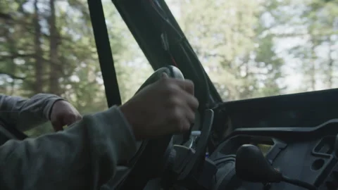 Close up shaky shot of mans hands driving UTV against forest backdrop Stock Footage 321376583
