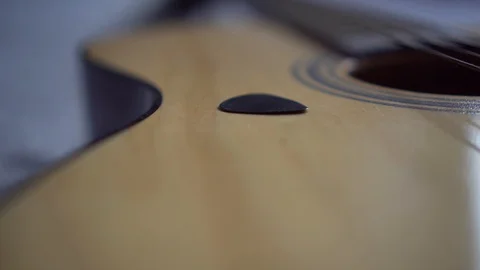 Close up shallow depth of field of plectrum on top of a guitar laying on a bed Video stock 91016581