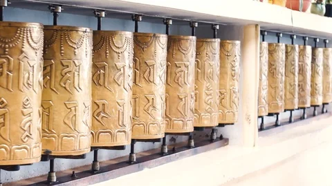 Close up shallow depth fo feild shot of golden bhuddhist prayer wheels spinning Stock Footage 114653660