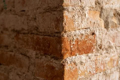 Close-up of a sharp corner of a red brick wall with thick, messy grey mortar Stock Photos