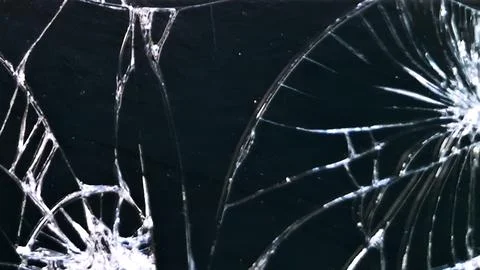 Close up of sharp cracks on a shattered black glass surface Stock Photos