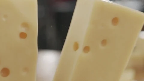 Close-up of sharp knife chopping hard cheese in slow motion Stock Footage 120402623