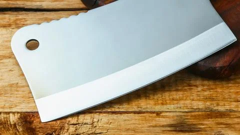 Close up of a sharp metal meat cleaver on a wooden surface Stock Photos