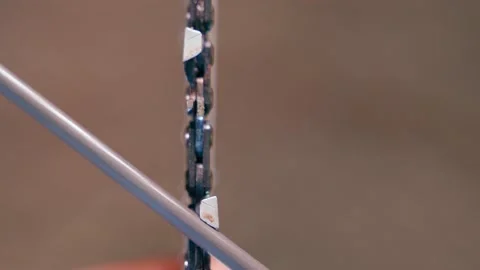 Close-up of sharpening a chainsaw chain with a round file. Preparing the tool Stock Footage 207622203