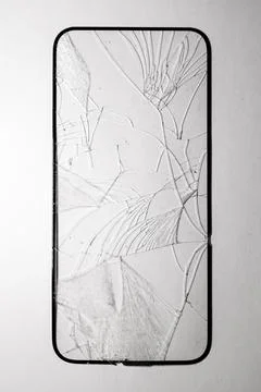 Close-up of shattered smartphone screen with spiderweb-like cracks Foto stock
