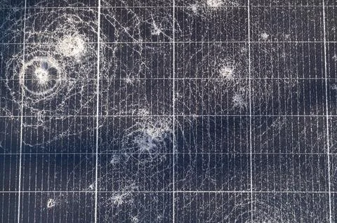 Close-up of shattered solar panel surface with multiple impact cracks and d.. Stock Photos
