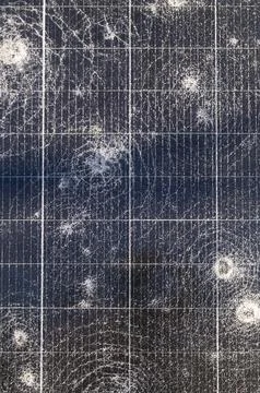 Close-up of shattered solar panel surface with multiple impact cracks and d.. Stock Photos