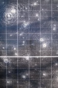 Close-up of shattered solar panel surface with multiple impact cracks and d.. Stock Photos
