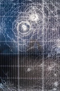 Close-up of shattered solar panel surface with multiple impact cracks and d.. Stock Photos