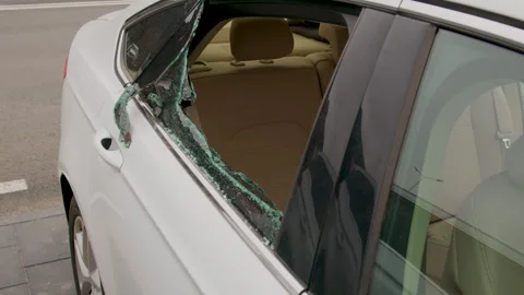 A close-up of a shattered window of a car parked in a lot, illustrating an act Vidéo 267073788