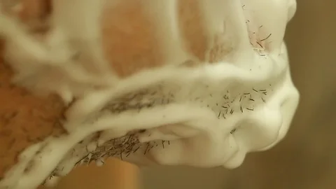 Close-up of shaving bristles from the face of a man with a shaving machine Stock Footage 82280875