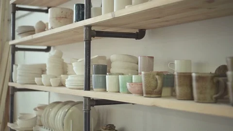 Close up of shelves in bright ceramic studio with dishes on it. Stock Footage 88412526