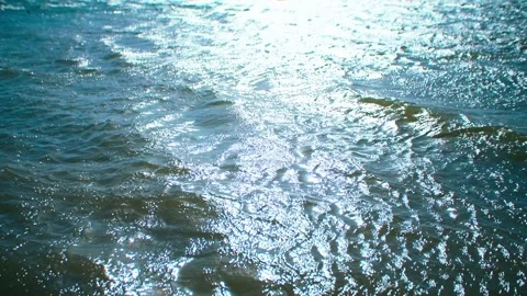 Close-up of shimmering light spots and rippling waves on the lake surface. Stock Footage 345591693