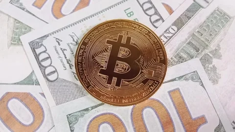 Close-Up of shiny bitcoin crypto currency coins on top of a 100 dollar bill Stock Footage 328441276