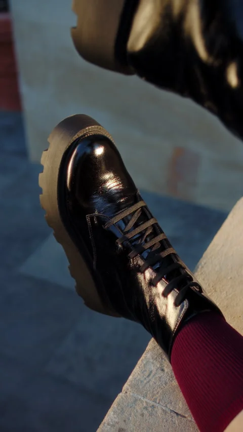Close-up of shiny black boots with thick soles and red socks Stock Footage 317335680