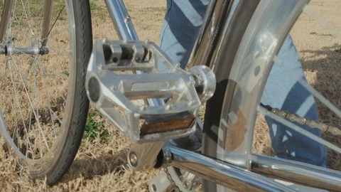 Close-up, shiny, chrome-plated classic bike. Brunette girl walking on dry grass Stock Footage 121885026