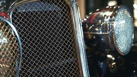 Close-up of shiny chrome radiator grill and headlight on vintage vehicle Stock Footage 340880318