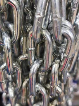 Close-up of shiny metal chains with interlinked steel texture and detail Stock Photos