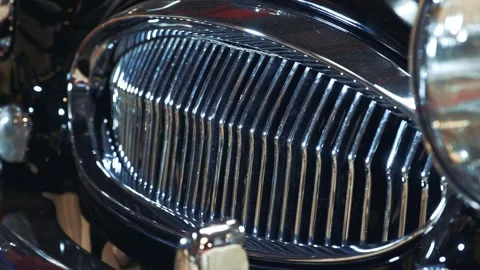 Close-up of shiny radiator grill and headlight on black vintage car Video stock 340880150