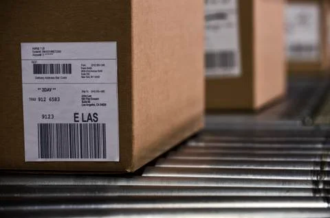 Close up of shipping lables with bar codes on cardboard boxes sitting on a Stock-Fotos
