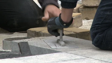 Close up shit of construction worker paving the brick road Video stock 130327174