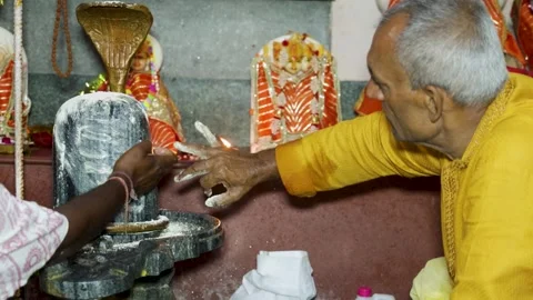 Close Up Of Shiva Lingam Worship With Devotees Performing Sacred Ritual Stockbeeldmateriaal 338079554