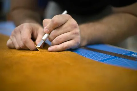 Close up of a shoemaker cutting leather in a workshop. Handmade and craft 写真素材