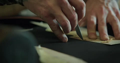 Close-up of a shoemaker cutting out leather pieces on table at the workshop. Stock Footage 246307555