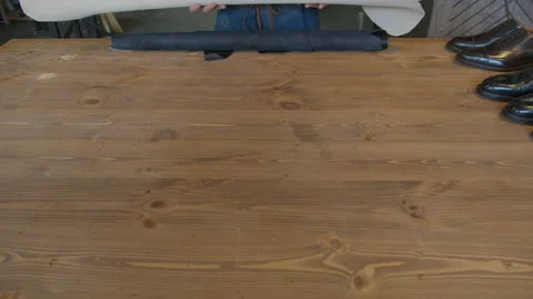 Close-up shoemaker hands rolling out leather material for making shoes. Shoe Stock Footage 137578681