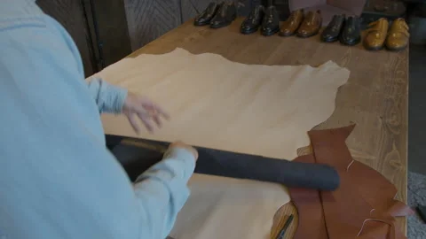 Close-up shoemaker hands rolling out leather material for making shoes. Shoe Stock-Footage 137579634