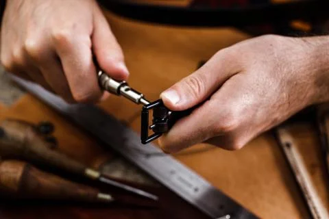 Close up of a shoemaker or artisan worker hands. Leather craft tools on old wood Stock Photos