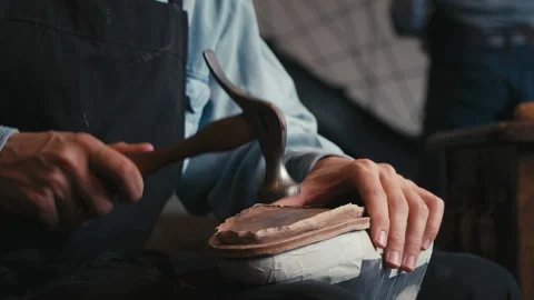 Close up shoemaker taps sole shoes with hammer. Workshop for production shoes Stock Footage 138306509